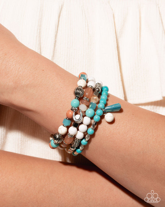 Stack of colorful beaded bracelets on a wrist against a white background