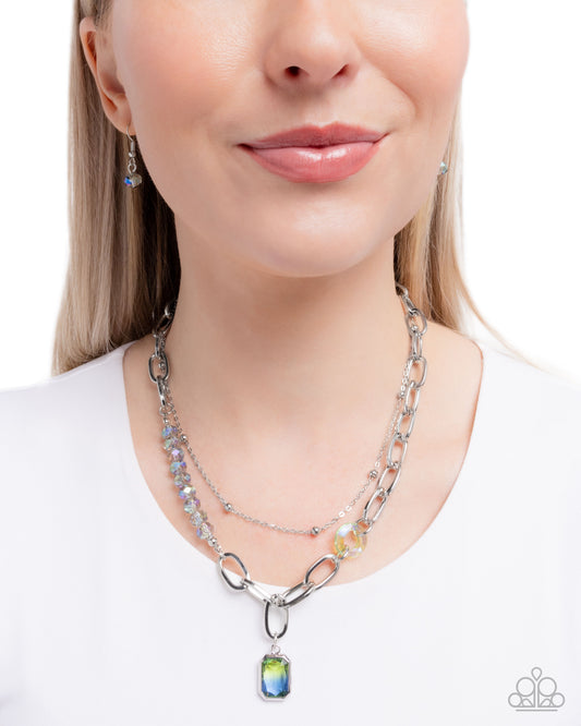 Woman wearing a silver chain necklace with a colorful pendant on a white background