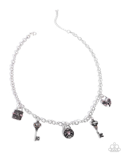 Silver necklace with various charms on a white background