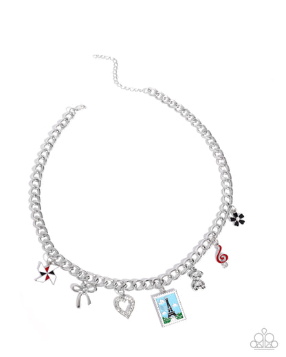 Silver chain necklace with various charms on a white background