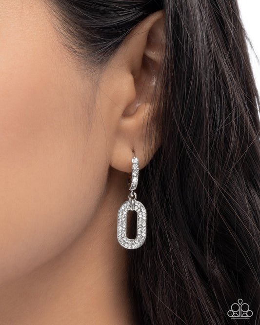 Earring worn by a person with dark hair on a white background