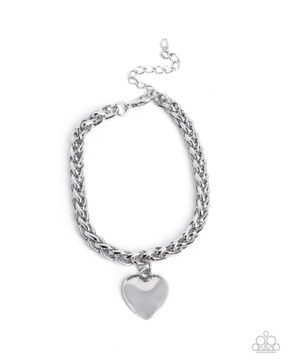 Silver chain bracelet with a heart charm on a white background
