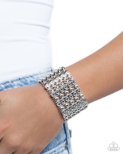 Silver bracelet on a wrist with a white background