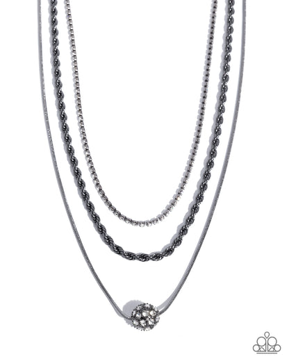 Three layered necklaces with a central pendant on a white background