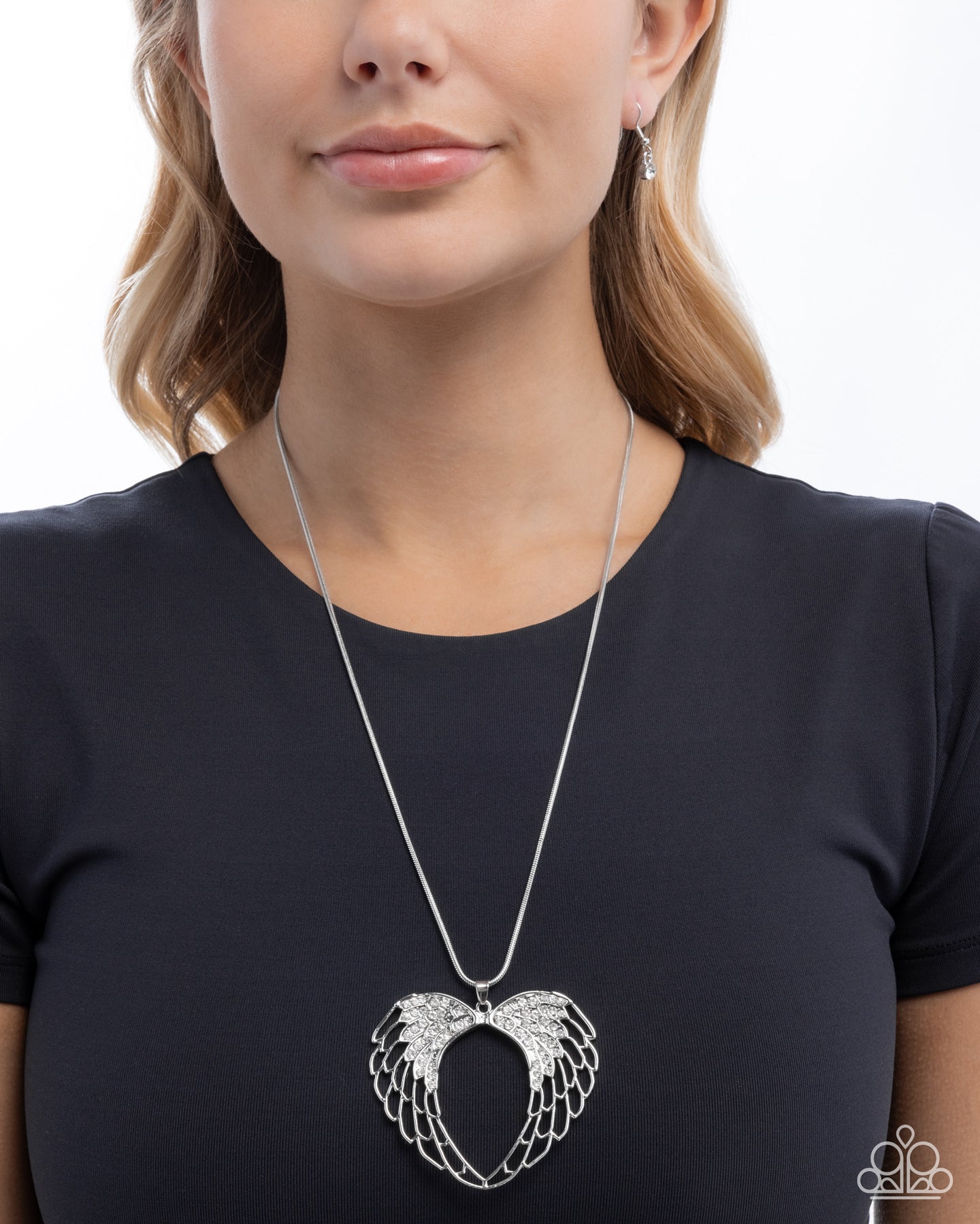 Woman wearing a silver necklace with an angel wing pendant on a white background