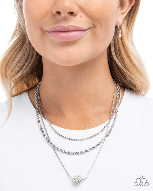 Woman wearing a silver necklace with a white background