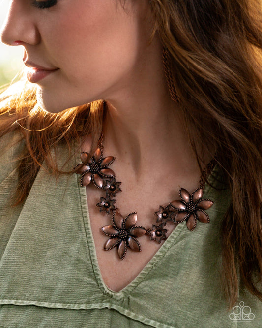 Close-up of a woman wearing a floral necklace with a green top.