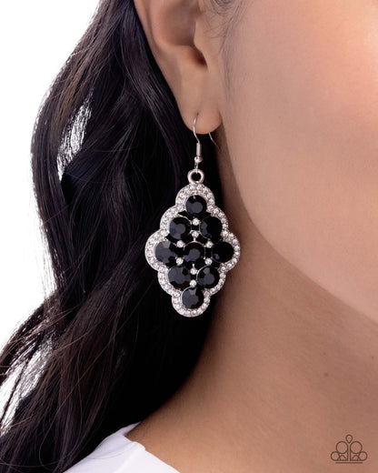 Black floral earring worn by a model with dark hair.