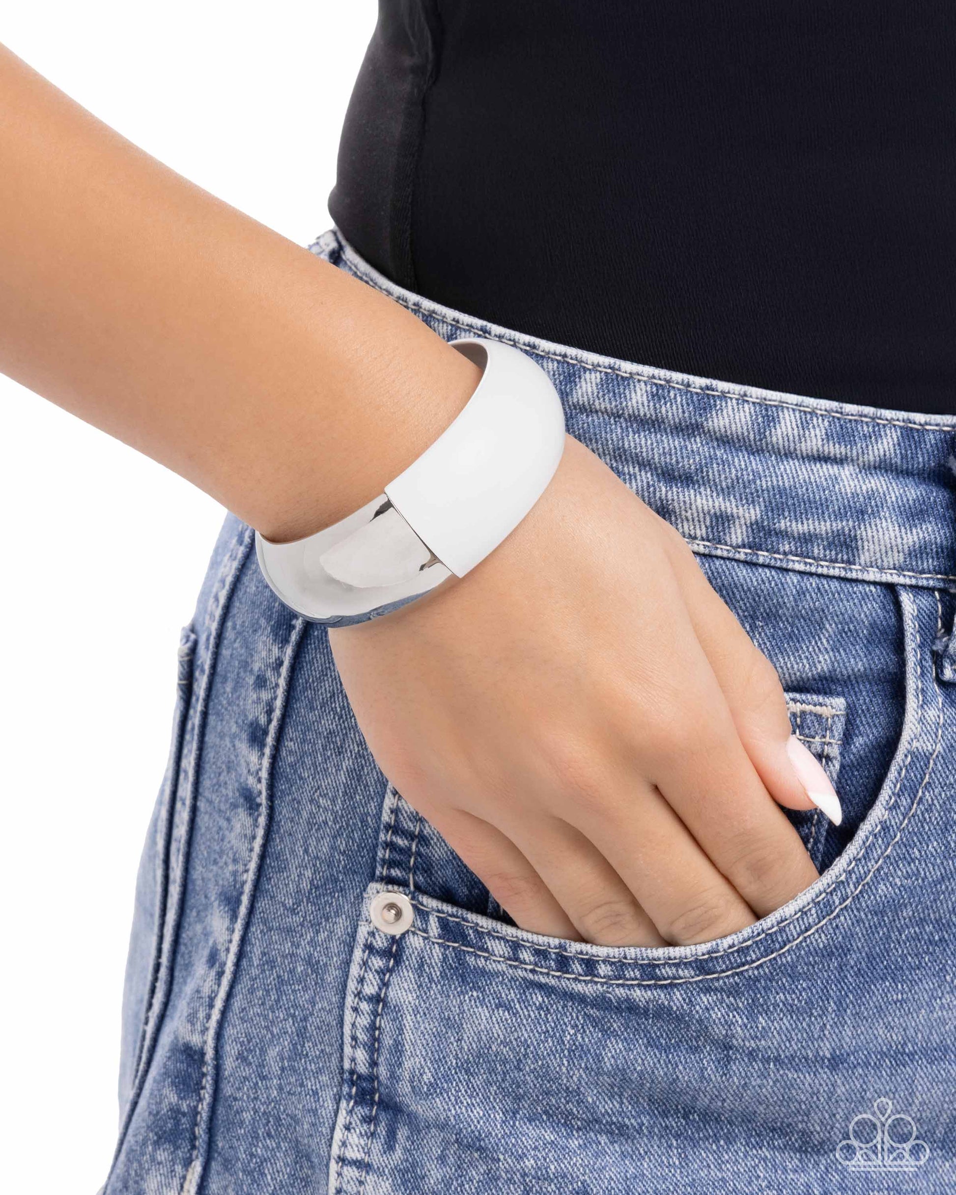 Person wearing a white bracelet on a plain background
