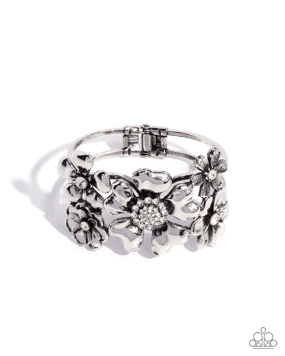 Silver floral ring with intricate designs on a white background