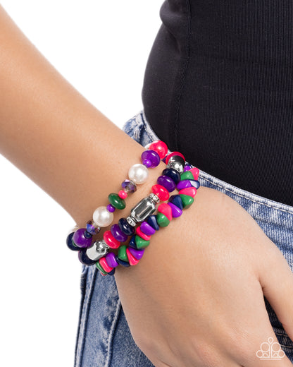 Colorful beaded bracelet on a wrist with a white background