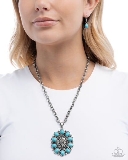 Woman wearing a turquoise necklace and earrings on a white background