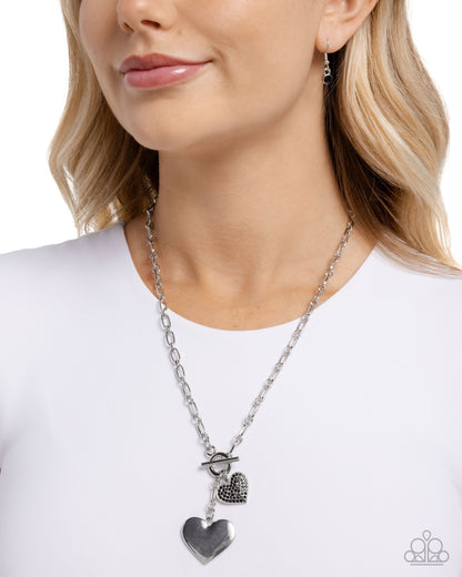 Necklace with heart pendants worn by a model on a white background