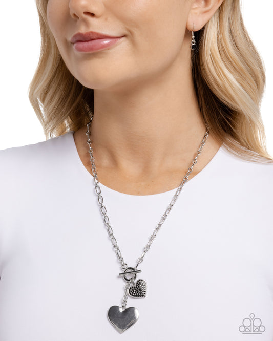 Necklace with heart pendants worn by a model on a white background
