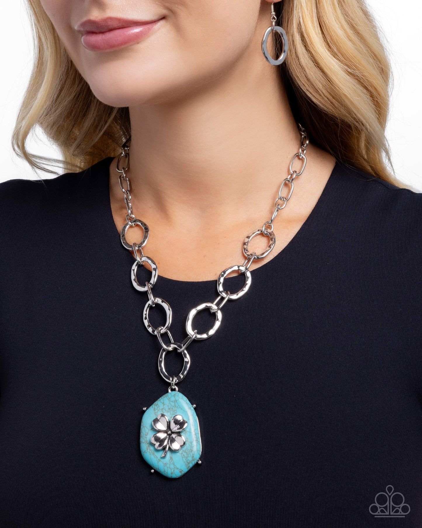 Turquoise pendant necklace with silver chain on a model wearing a black top.