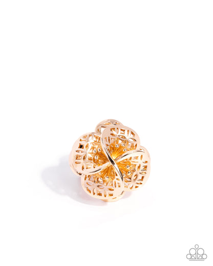Gold ring with intricate design on a white background