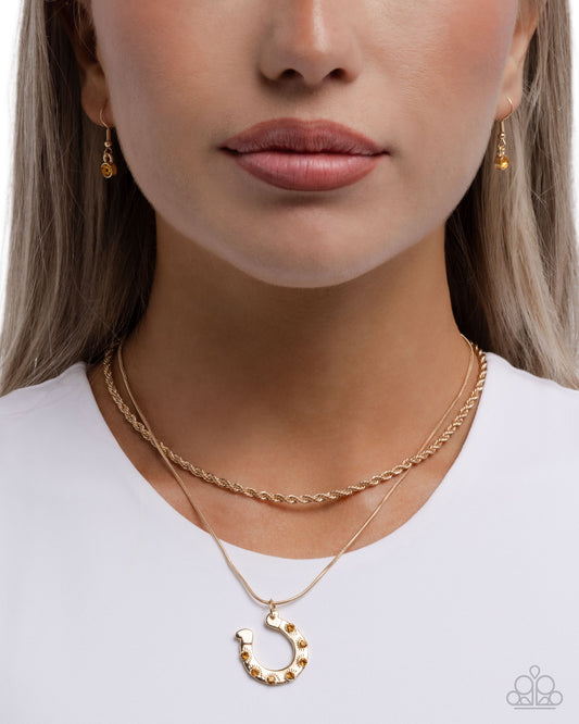 Close-up of a person wearing gold necklaces and earrings on a white background