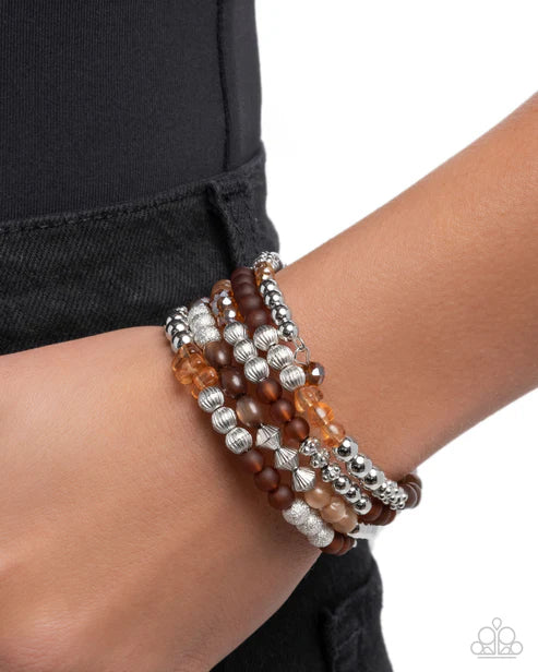 Stack of beaded bracelets on a wrist with a black background