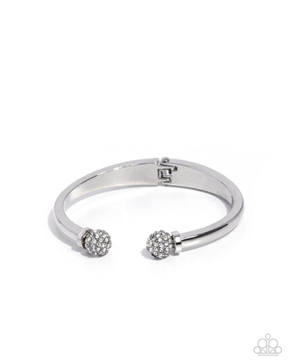 Silver bracelet with two spherical charms on a white background