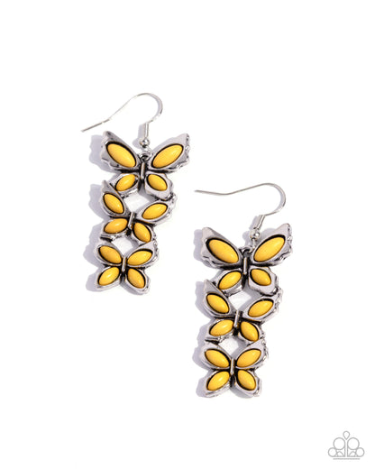 Butterfly-shaped earrings with yellow centers and silver frames on a white background