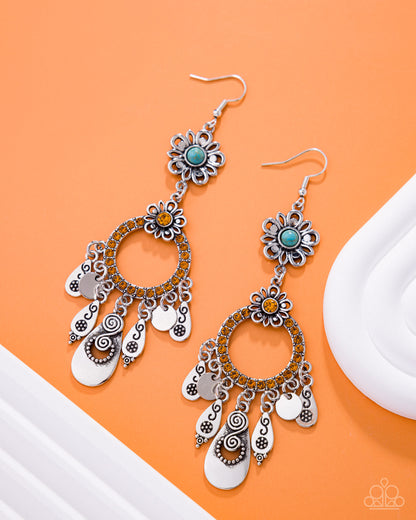 Pair of silver and turquoise floral earrings on an orange background