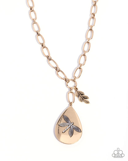 Gold necklace with teardrop pendant and leaf charm on a white background