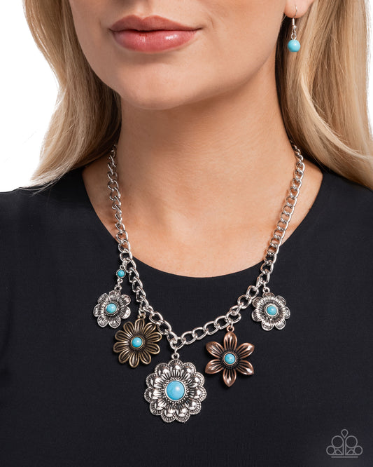 Necklace with floral pendants and turquoise stones worn by a person on a black background