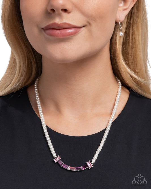 Pearl necklace with pink gemstones worn by a model on a white background