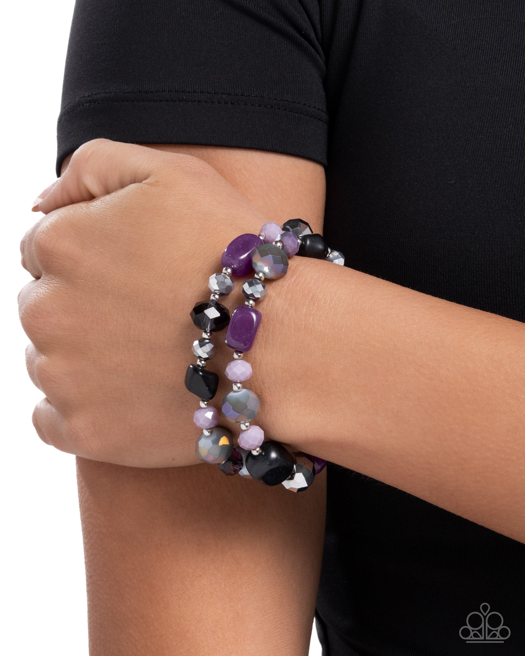Multicolored beaded bracelet on a wrist with a black sleeve