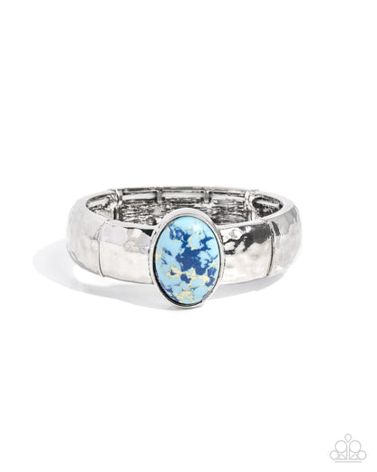 Silver ring with a blue gemstone on a white background