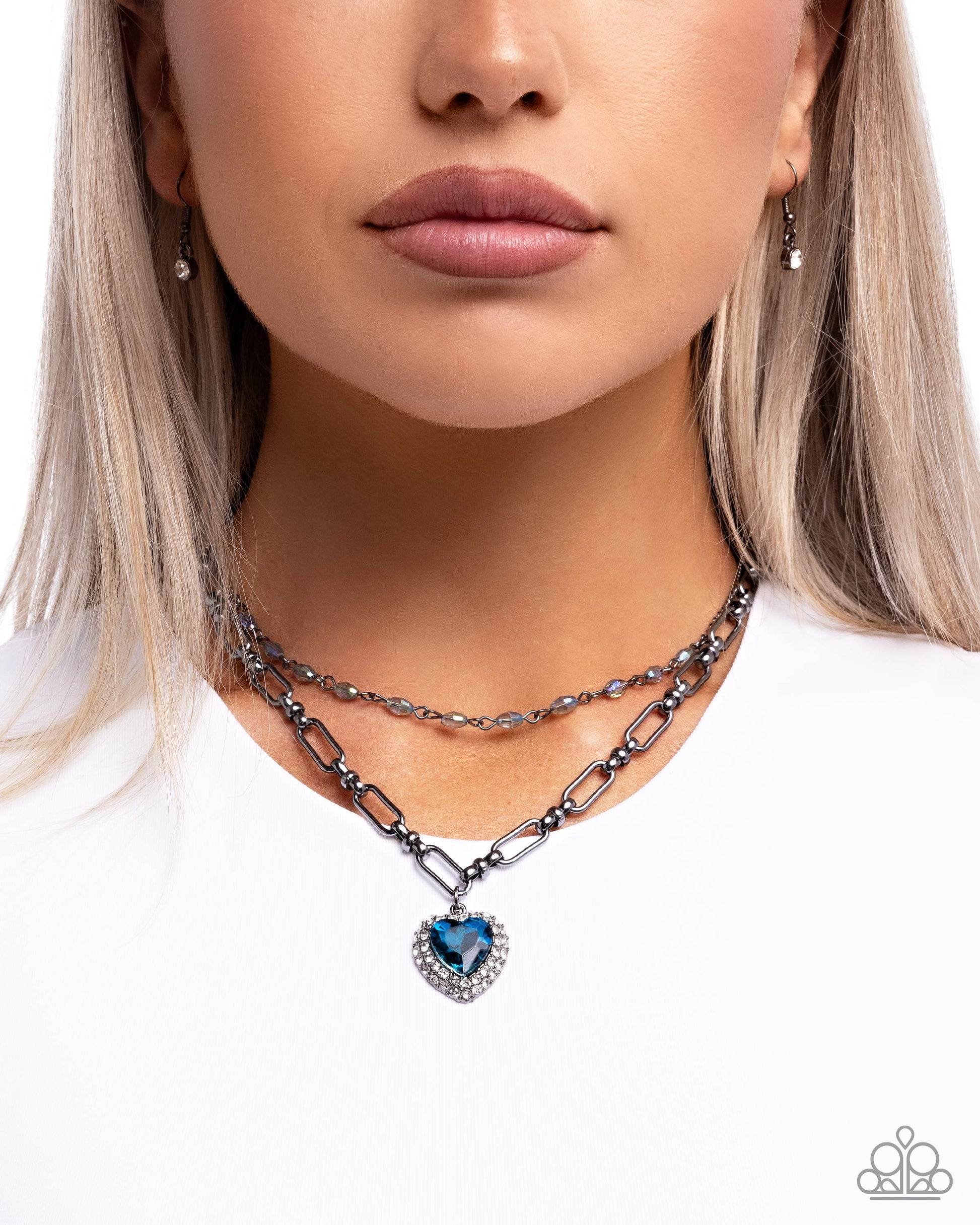 Necklace with heart-shaped blue gemstone pendant worn by a model on a white background