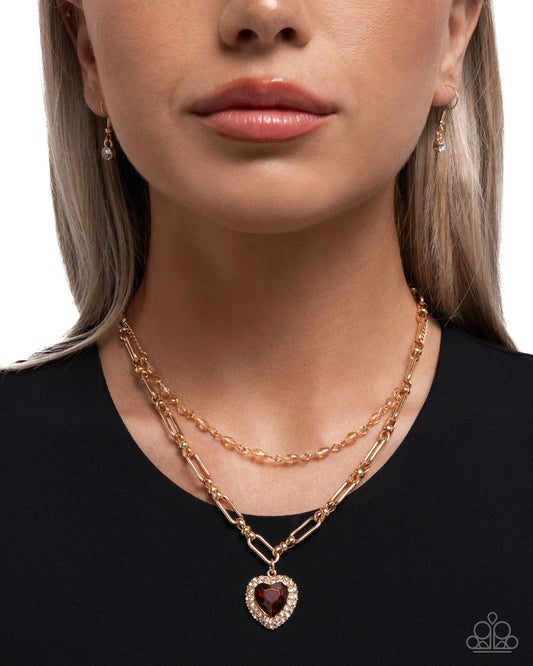 Close-up of a woman wearing a rose gold necklace with a heart pendant on a plain background