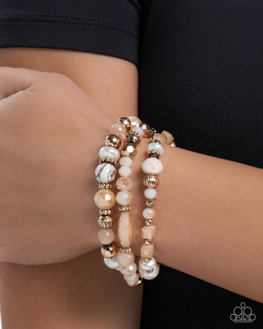 Stack of beaded bracelets on a wrist against a black background
