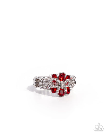 Ring with red gemstones and silver accents on a white background