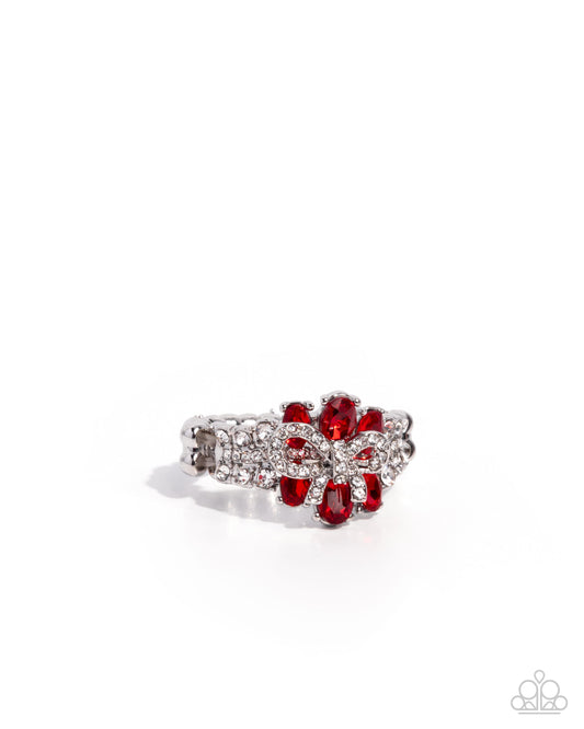 Ring with red gemstones and silver accents on a white background