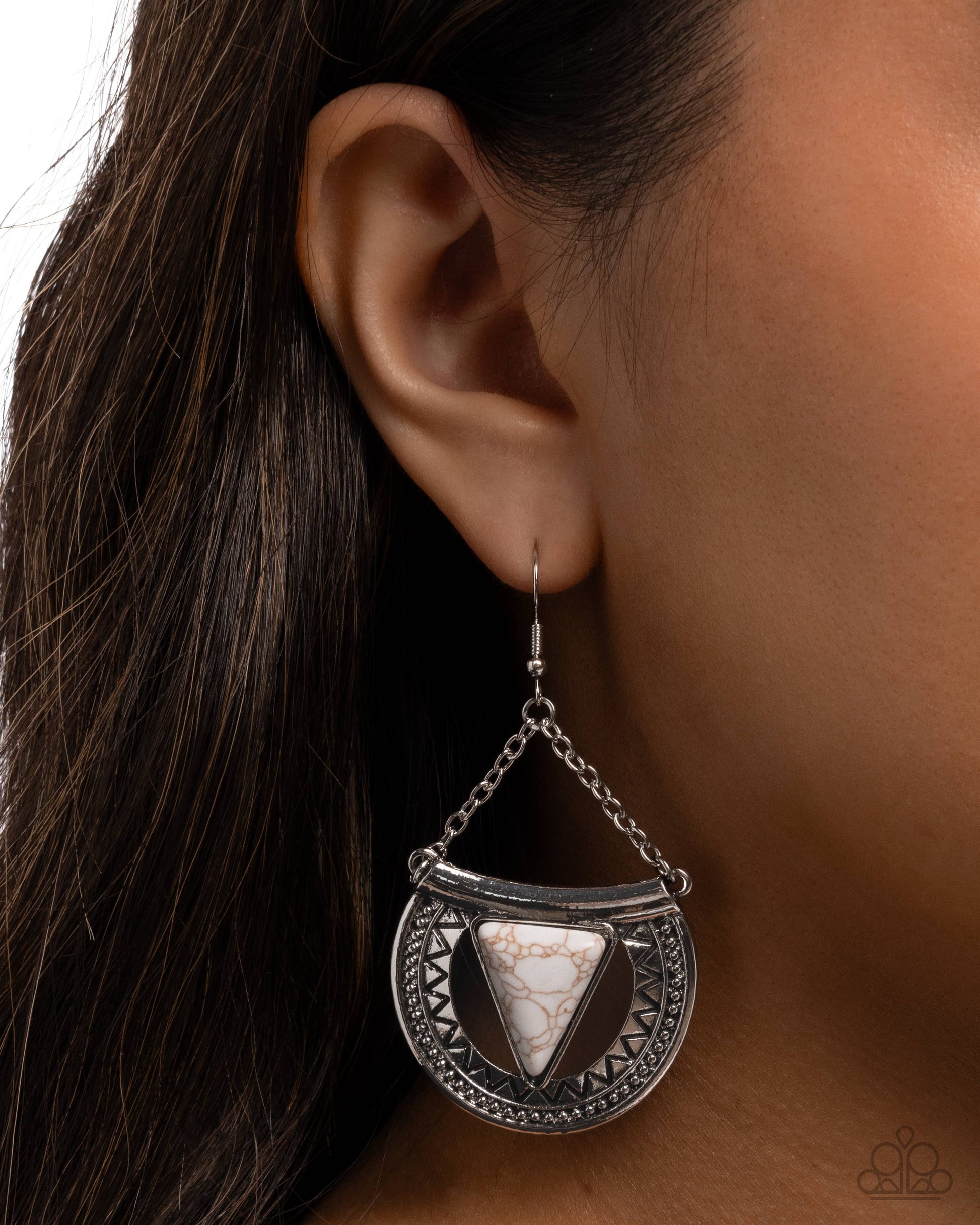 Silver earring with triangular design worn by a person
