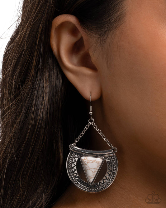 Silver earring with triangular design worn by a person