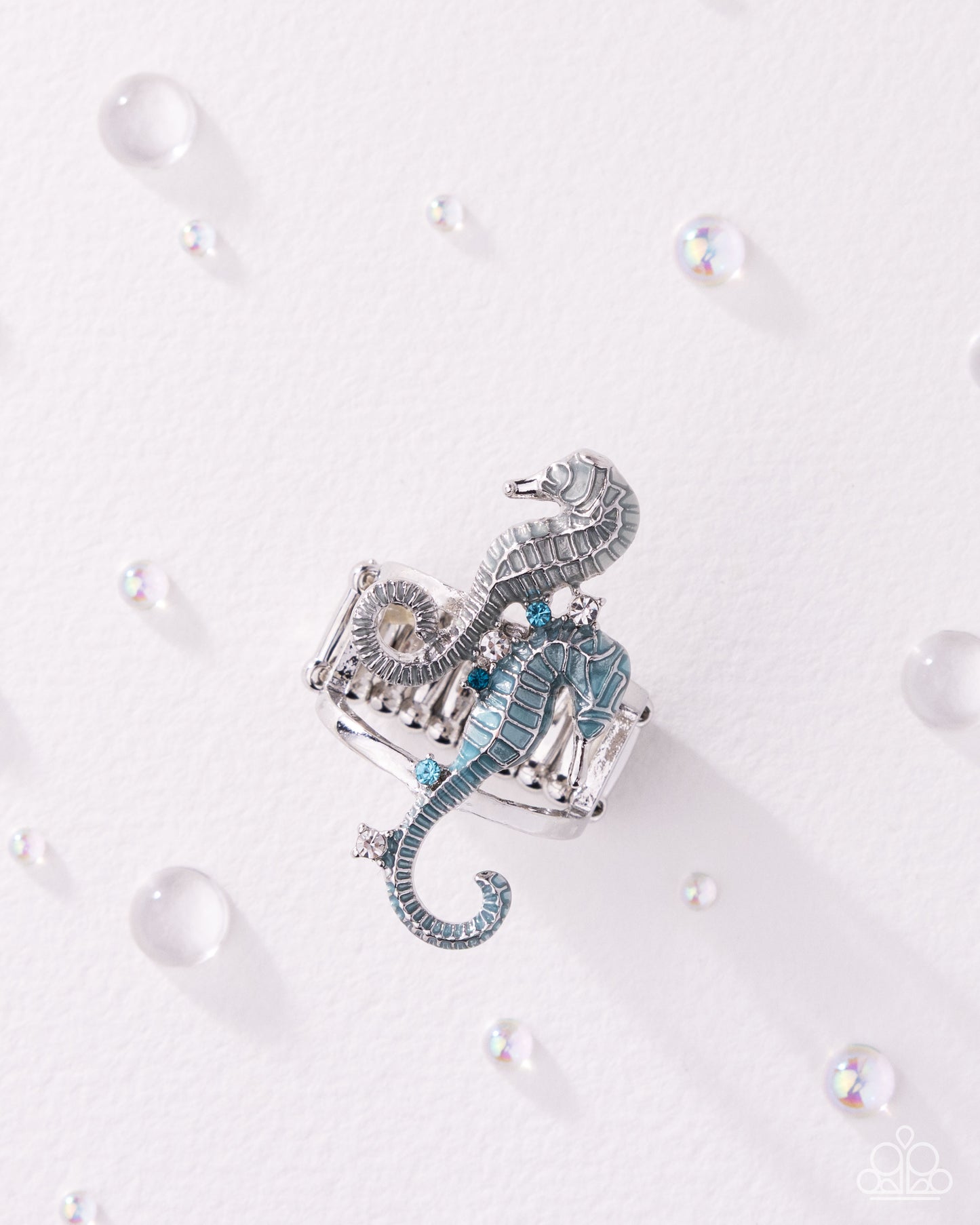 Decorative seahorse ornament on a white background with pearls