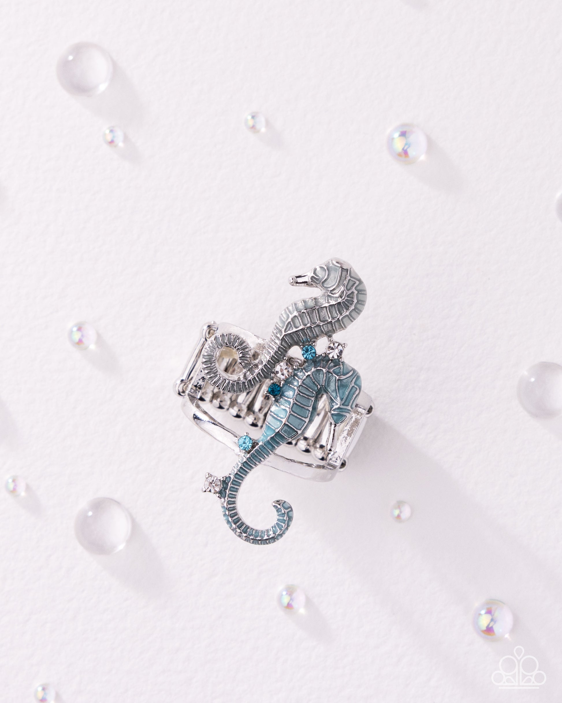 Decorative seahorse ornament on a white background with pearls