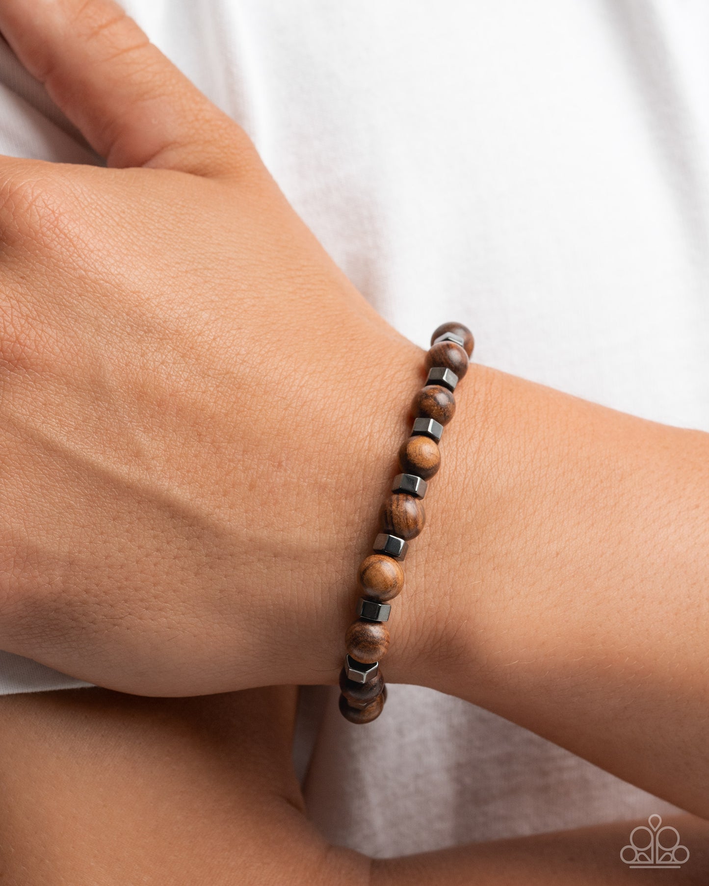 Wooden beaded bracelet on a wrist with a white background