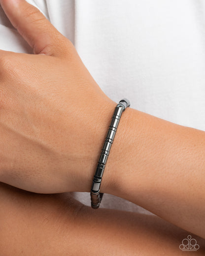 Silver bracelet on a wrist against a white background