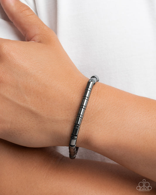 Silver bracelet on a wrist against a white background