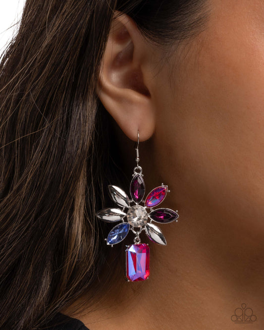 Close-up of an ear wearing a decorative earring with gemstones.