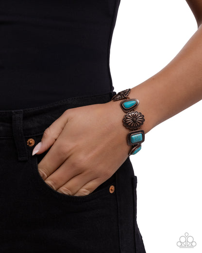 Turquoise and bronze bracelet on a wrist with a black background