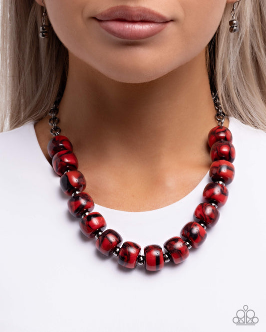 Red and black beaded necklace worn by a model on a white background