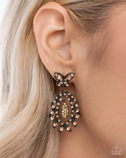 Close-up of an ear wearing a decorative earring with a blurred background