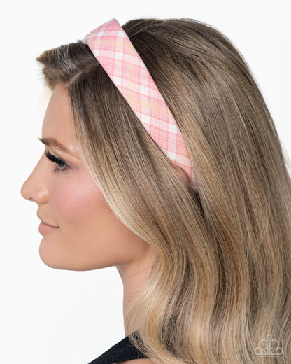 Woman wearing a pink plaid headband on a white background