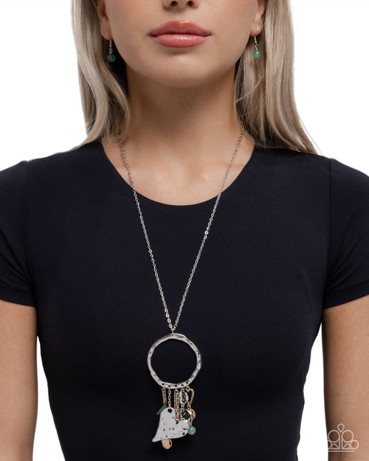 Woman wearing a long necklace with a pendant on a white background