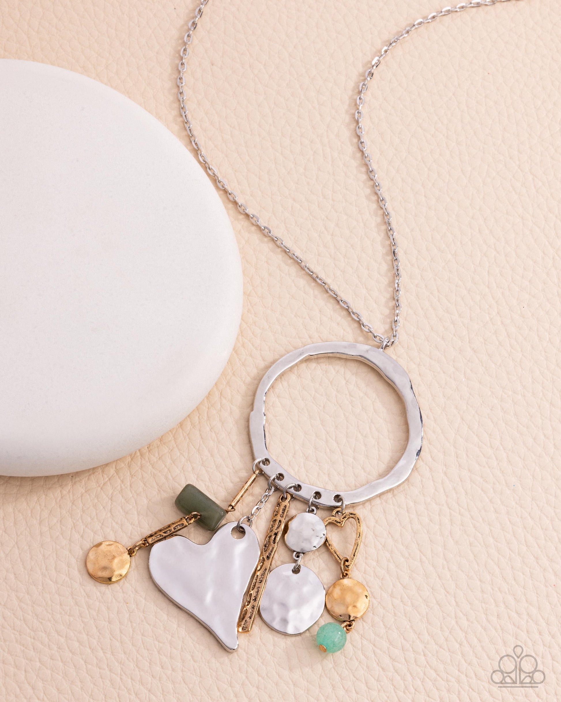 Necklace with various charms on a beige surface