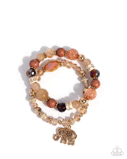 Stack of beaded bracelets with an elephant charm on a white background